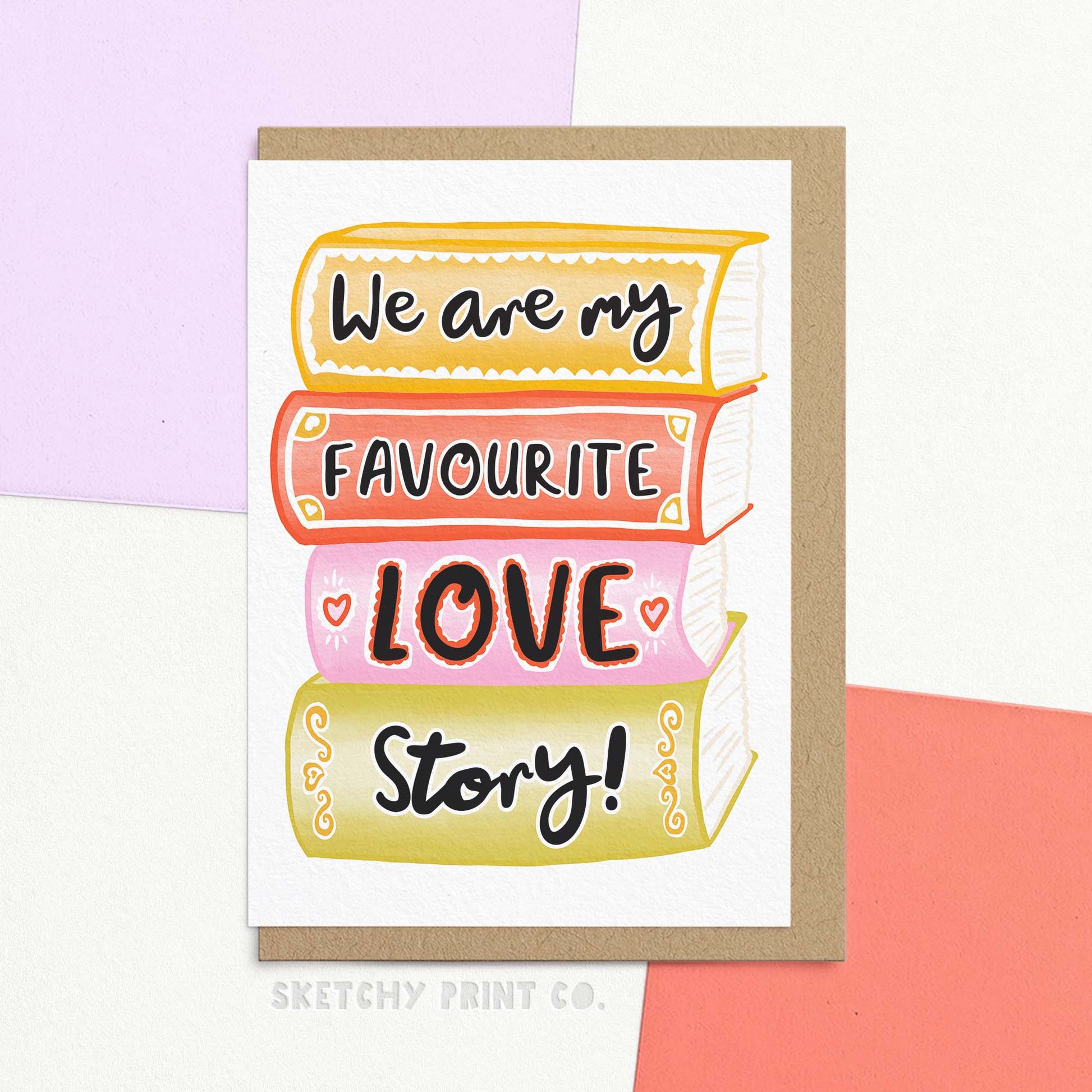 A high-quality photo of a cute anniversary card. The card features hand-drawn text reading "We are my favourite love story" on a stack of illustrated books, and is positioned to show the texture of the thick, FSC-certified card stock.