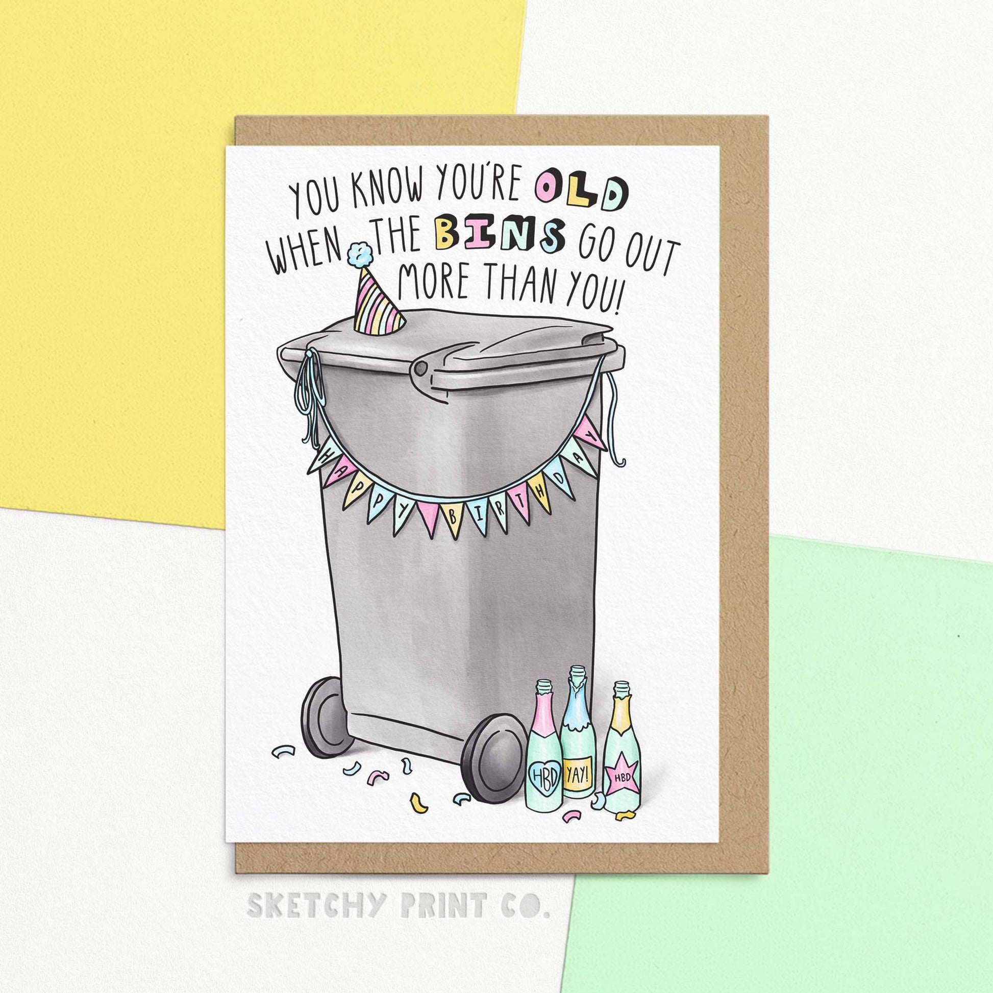 Funny birthday card with illustration of party bin and text 'you know you're old when the bins go out more than you!'. Show with a Kraft envelope.