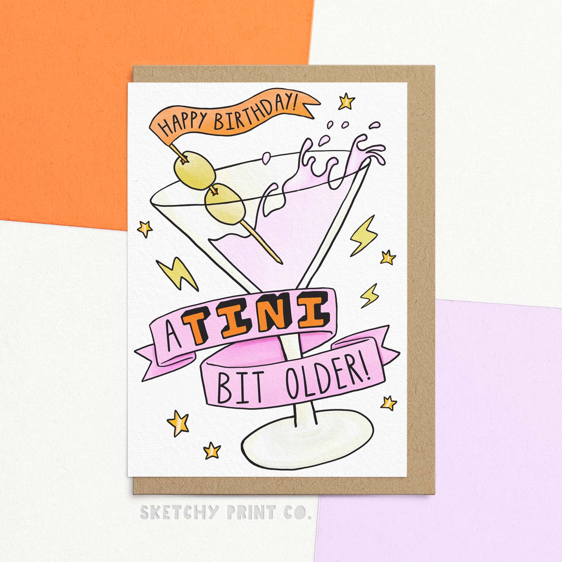 Stylish birthday card with martini illustration reading 'a tini bit older'. Cocktail stick says 'Happy Birthday!'. Shown with envelope.
