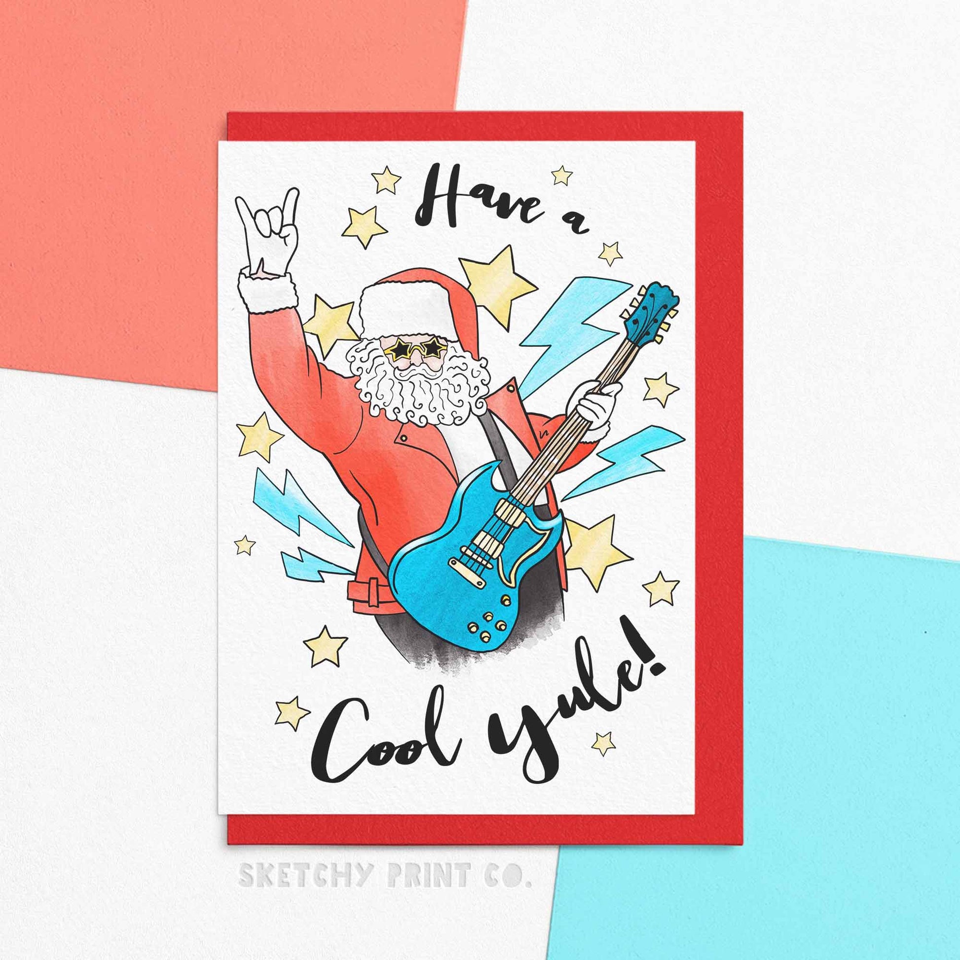 Funny Xmas greeting card featuring a rock an roll Santa, reading Have a cool yule. Celebrate the holidays in style with "Have A Cool Yule"! This funny Xmas greetings card features a rock and roll Santa that will spread some holiday cheer (and a few laughs!) to your loved ones. Get ready to rock around the Christmas tree with this cool card that yule absolutely love!