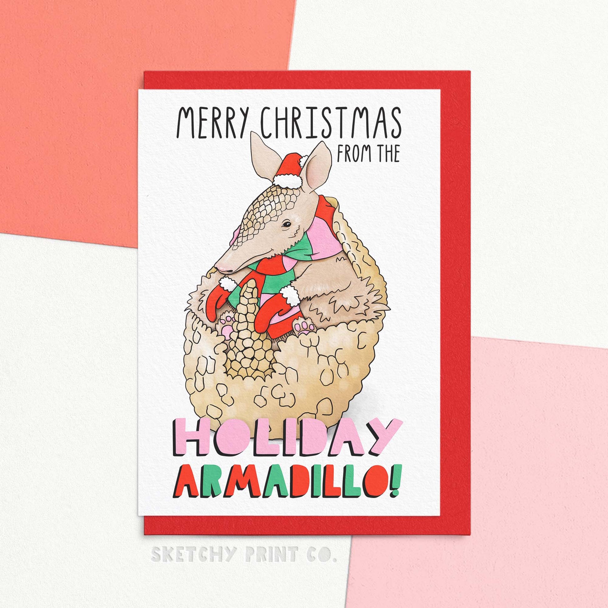 funny Christmas wishes card featuring a cute watercolour illustration of an armadillo in a Christmas hat & mittens, reading Merry Christmas from the holiday armadillo! Send funny Merry Christmas wishes with your part Jewish friend!&nbsp;Celebrate the holidays with our funny Xmas greetings card. This cute and quirky card is perfect for TV and animal lovers alike. 