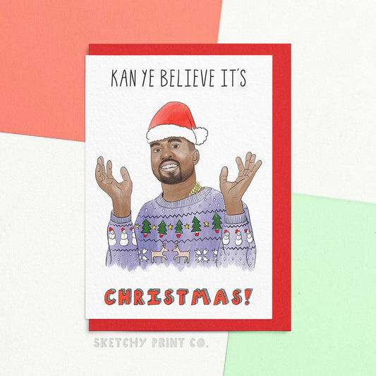 Funny Christmas wishes card reading kan ye believe it's Christmas! with an artists interpretation of a male rapper wearing a Christmas hat and jumper. Get ready to jingle all the way with our funny Xmas greetings card! Full of funny merry Christmas wishes, this card is a perfect holiday gift for music fans. Spread some holiday cheer and puns with this festive card. (Christmas gift rap not included!)