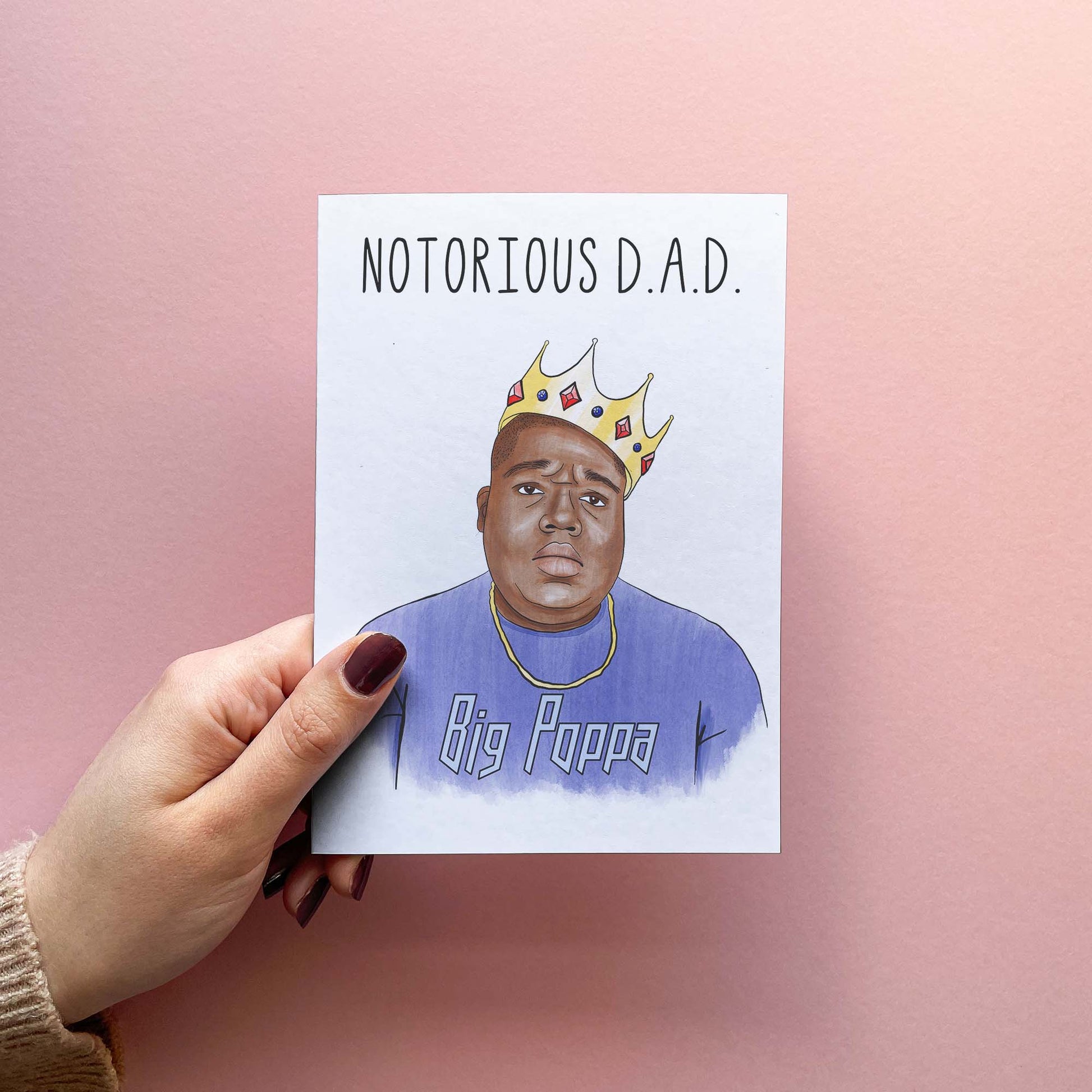 Funny Father's Day Card reading 'Notorious D.A.D' for 90s music fan. Father jokes aside, this card can also be used as the perfect happy birthday greeting card for your father to pair with unique Father's Day gifts! Card held in hand for size reference.