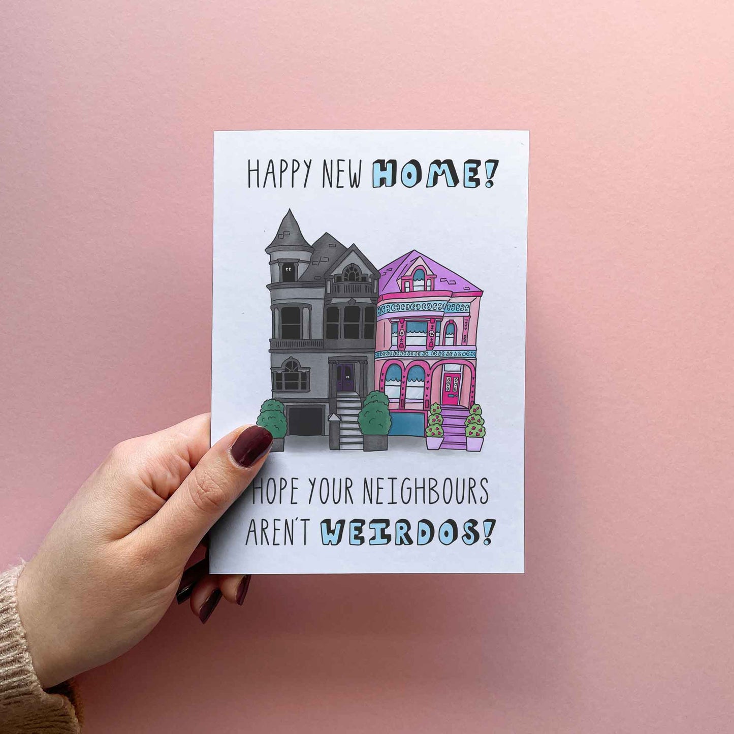  Funny new home / housewarming card reading 'Happy new home! Hope your neighbours aren't weirdos! Featuring an illustration of a spooky gothic house and pink barbie house next to each other.