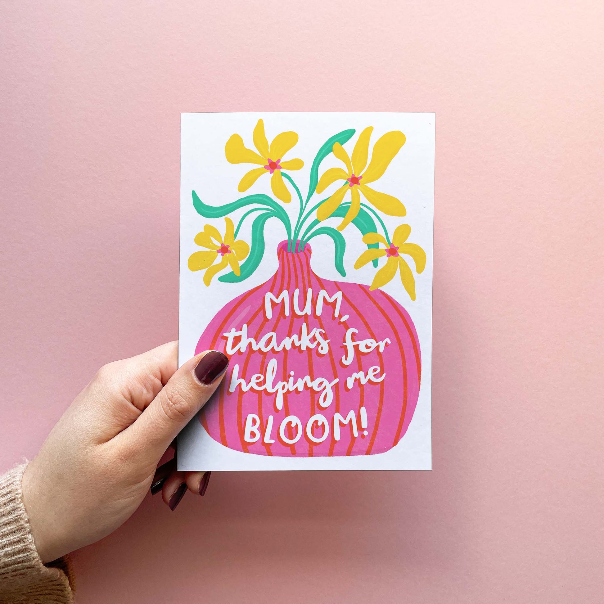 Cute Mothering Sunday card for mum featuring a modern and colourful hand-drawn illustration of a vase of flowers with the words "Mum, thanks for helping me bloom!" written on top. Card is shown being held.