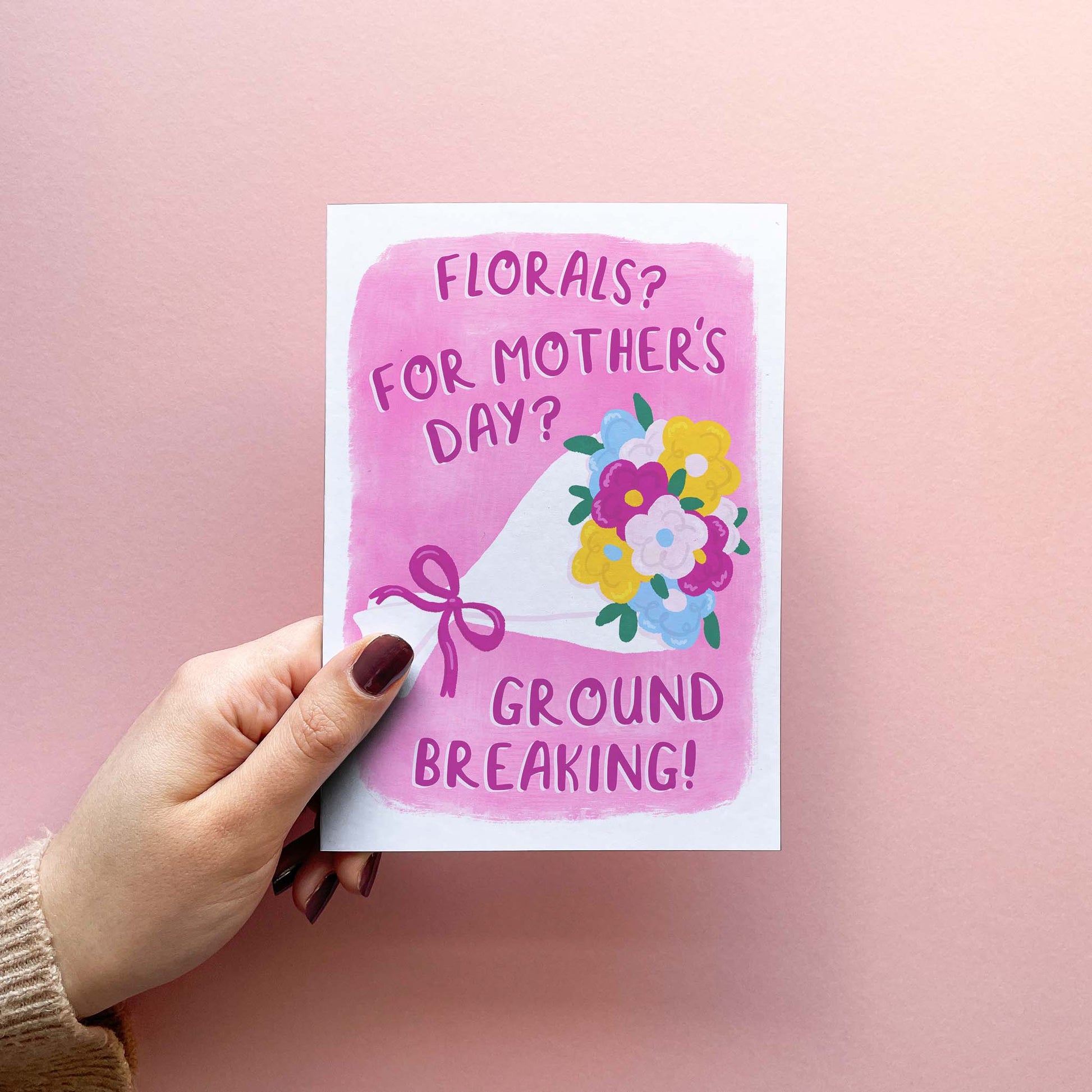Funny modern Mothering Sunday card featuring an illustration of a colourful bouquet tied with a bow, with the text "florals? For Mothers day? Groundbreaking!" a nod to everyones favourite fashion editor. The card is shown being held.
