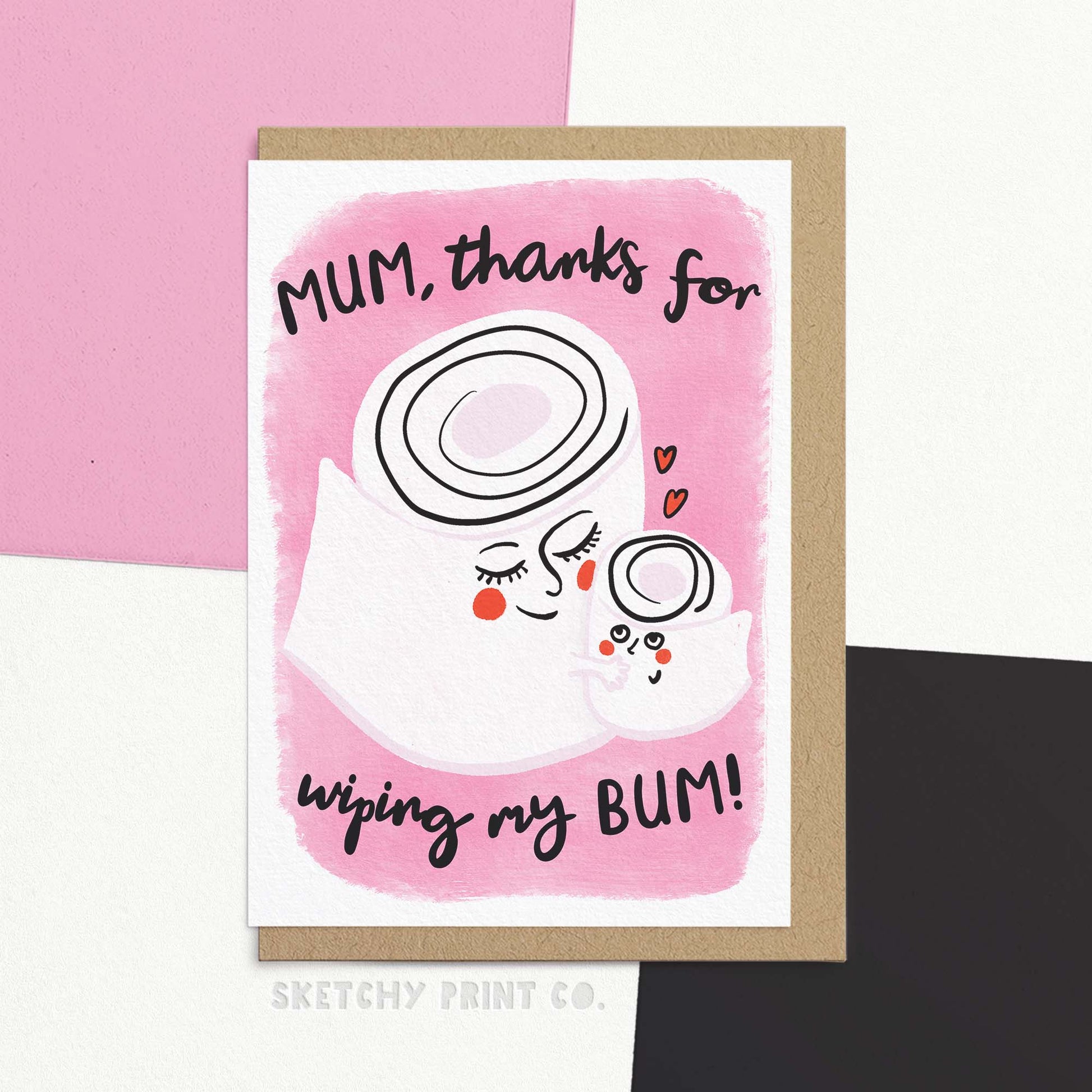 Funny and cute Mothers Day card for Mum, featuring a modern whimsical illustration of mum and child cartoon toilet rolls on a pink background with text  reading "Mum, thanks for wiping my bum!". Card is shown with a brown recycled Kraft envelope.